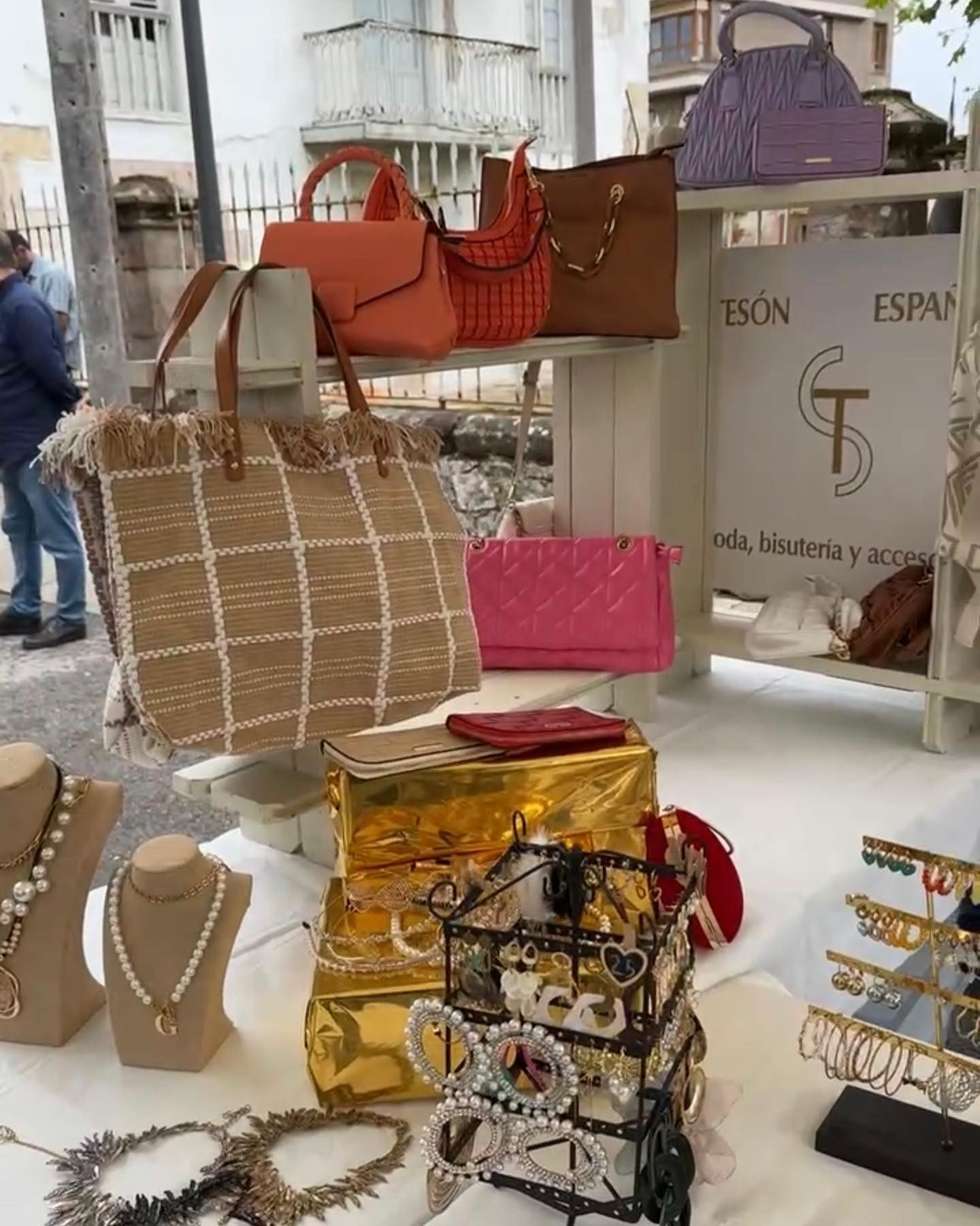 Una mesa con muchos bolsos y collares encima.