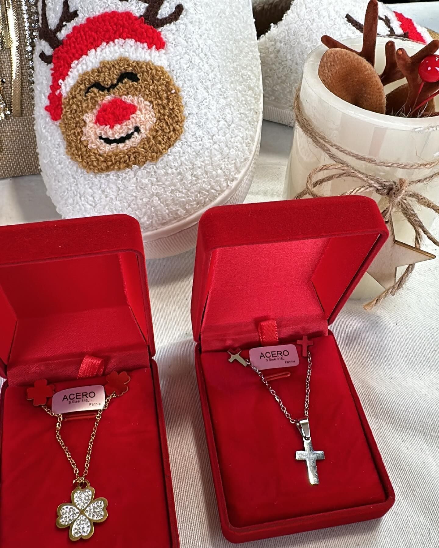 Dos collares están en cajas rojas sobre una mesa.