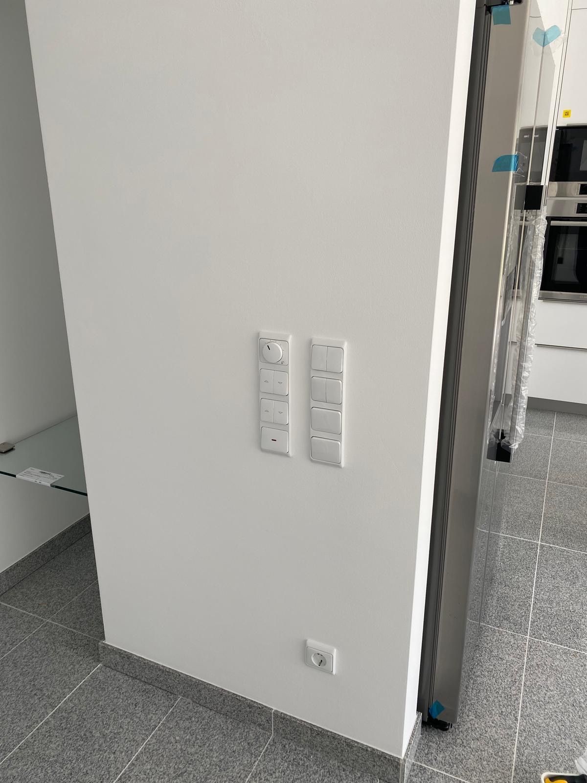 Fertig verputzte Wand mit Lichtschaltern und Steckdosen