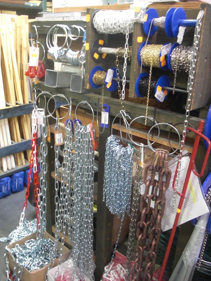 An einem Regal hängt Eisenware