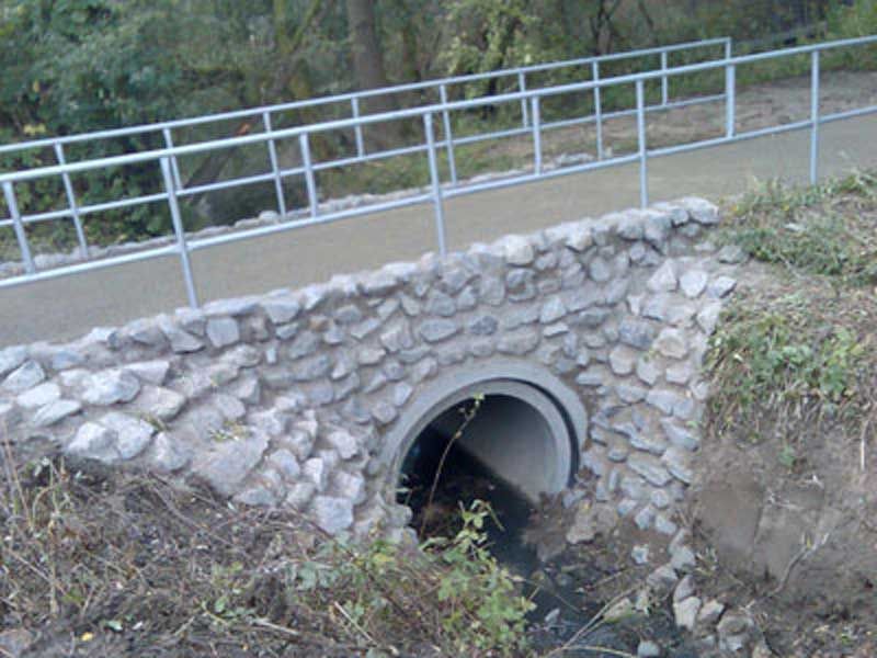 Ein Fluss fließt unter einer Steinbrücke hindurch in Löhne Falscheide