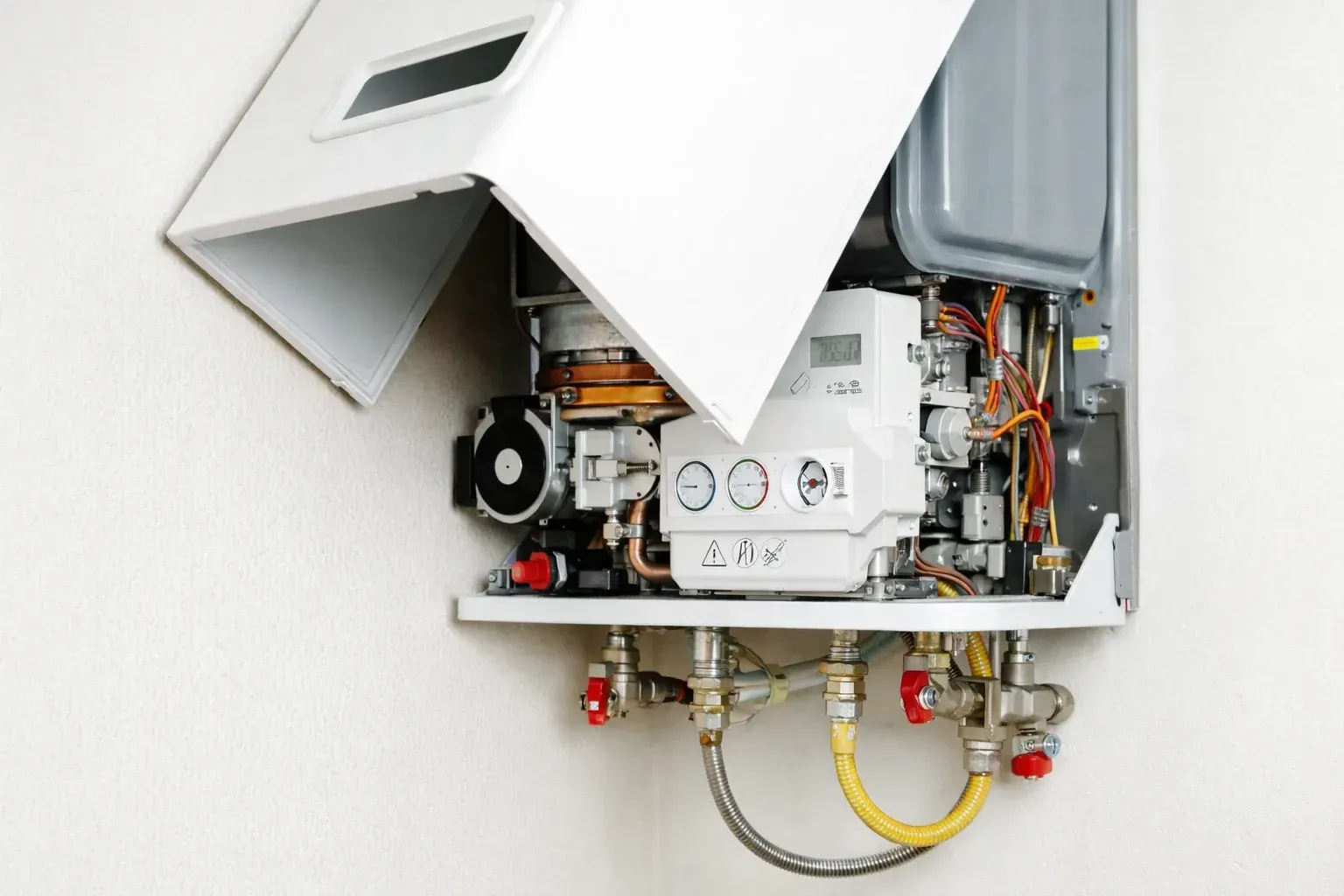 Una mano ajusta el dial de temperatura de un calentador de agua eléctrico blanco.