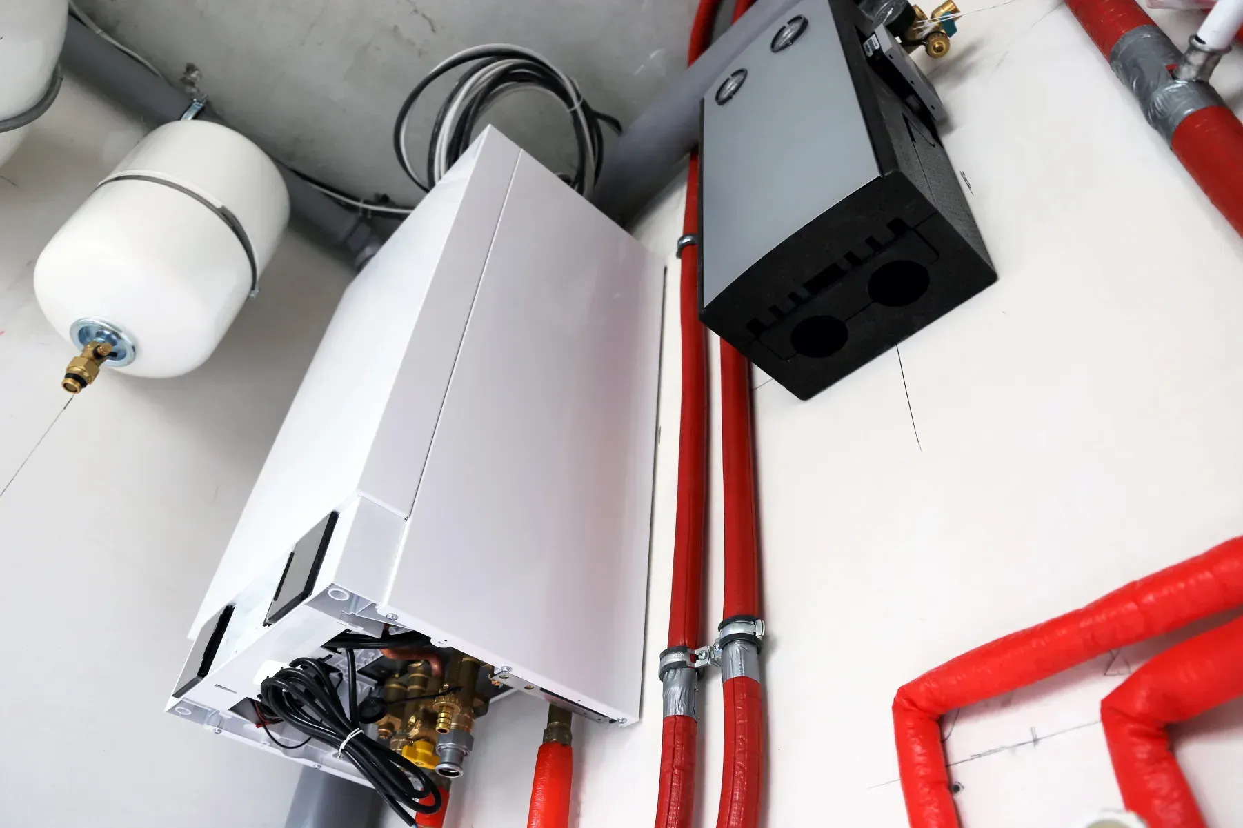 Equipo de climatización montado en una pared blanca, que consta de una unidad blanca, un componente gris