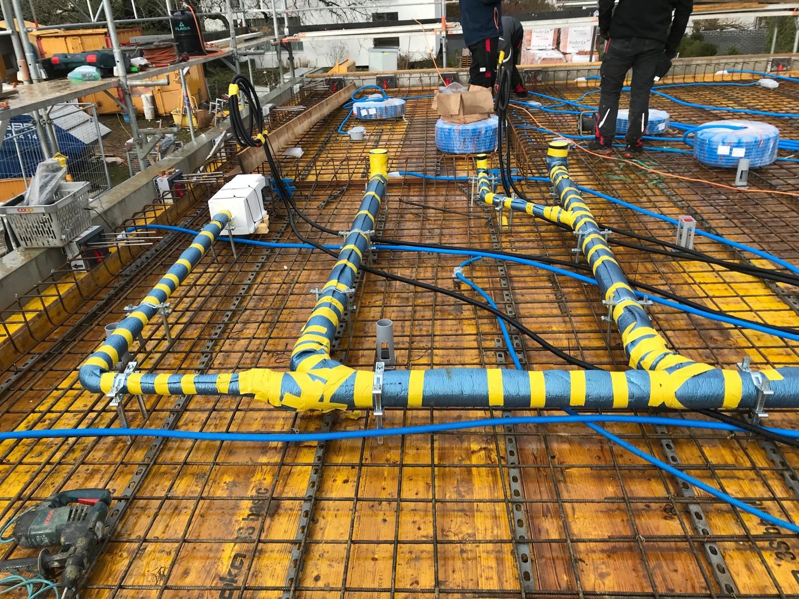 Ein Arbeiter benutzt eine rote Bodensäge, um Beton neben einer Mauer im Freien zu schneiden.