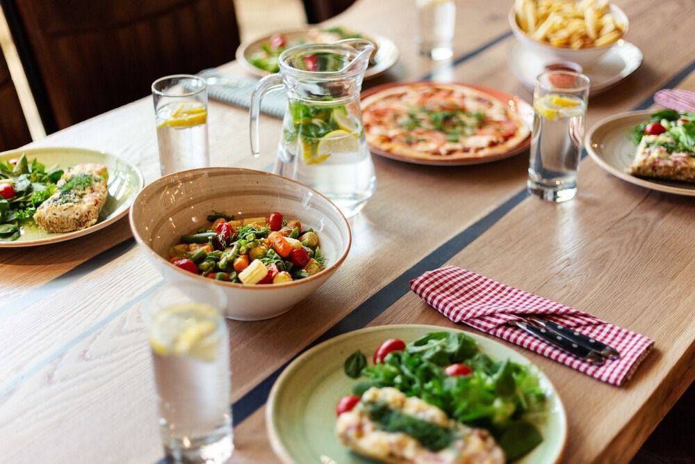 Una mesa de madera cubierta con platos de comida y bebidas.