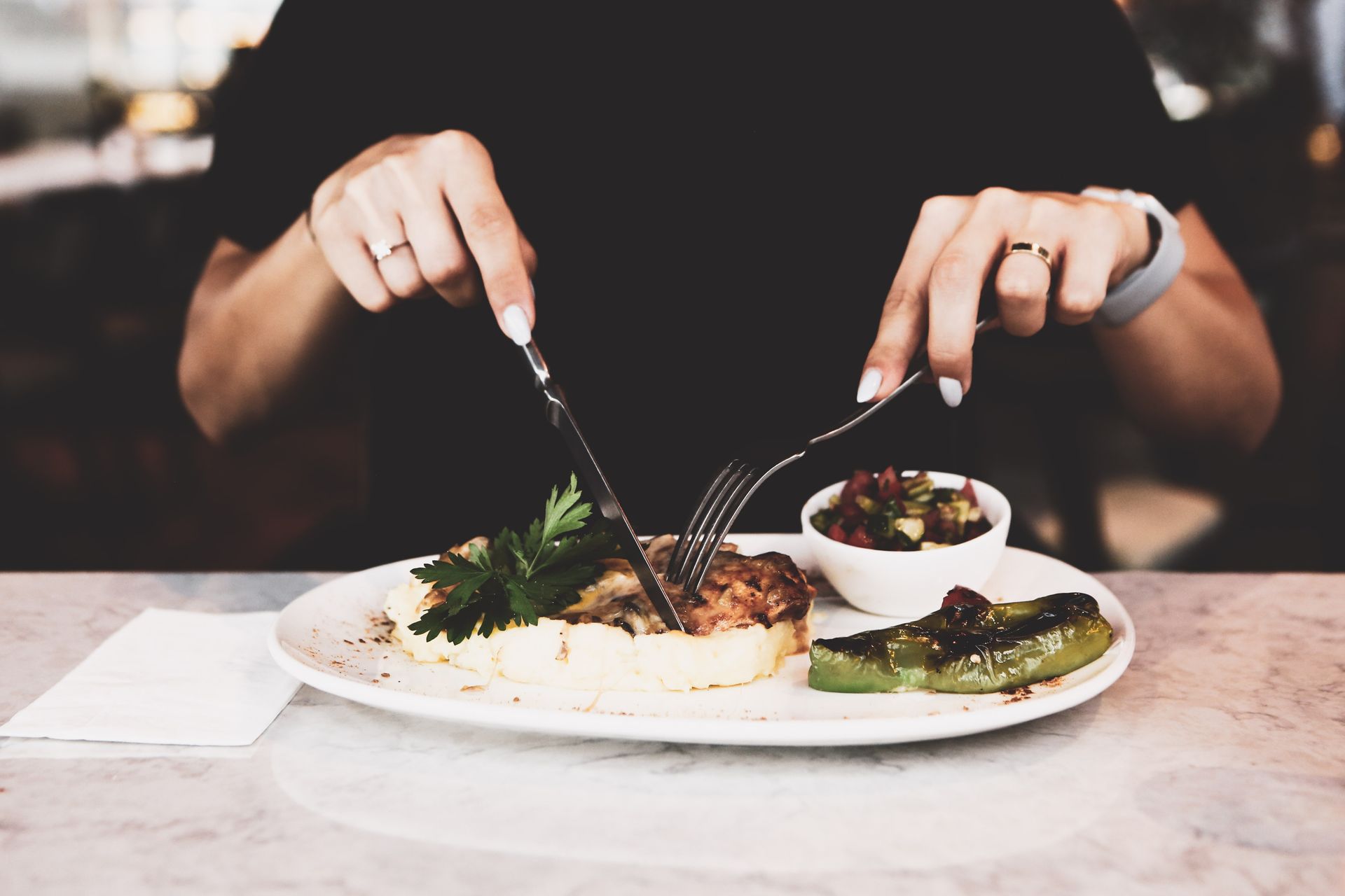 Una mujer está sentada en una mesa comiendo un plato de comida.