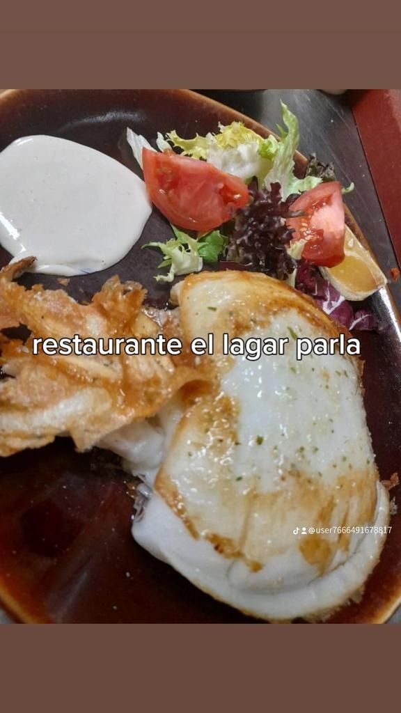 Un plato de comida con huevos, tomates y lechuga en una mesa.