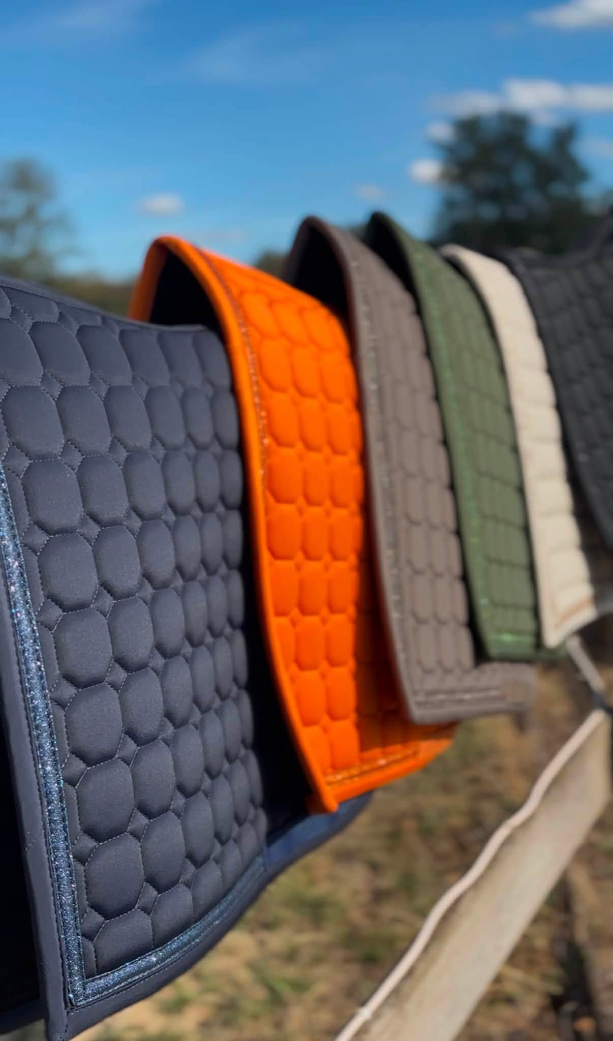 Tapis de selle matelassés colorés pour chevaux, suspendus à une clôture en plein air