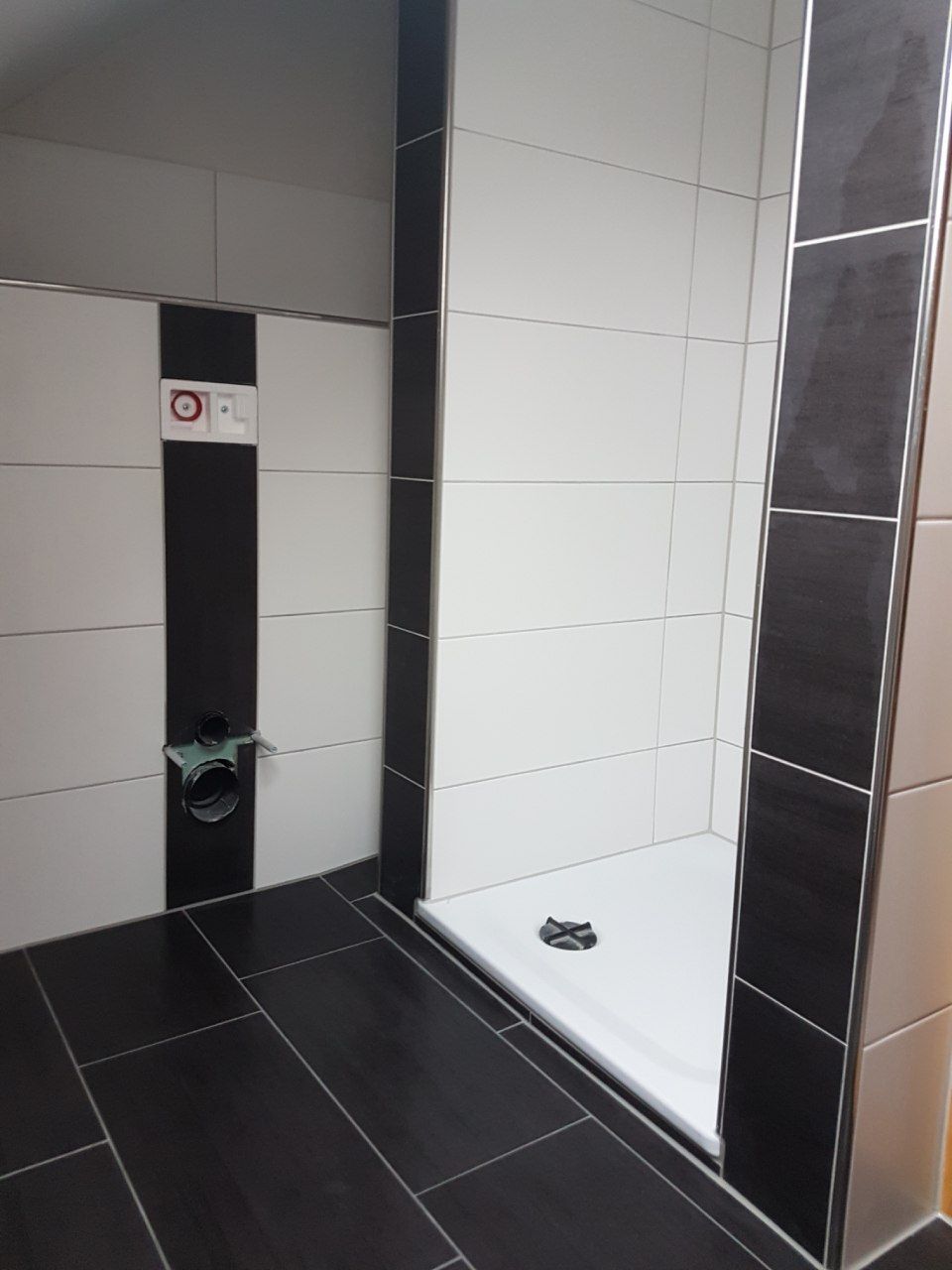 modernes Badezimmer mit weißen und dunklen Fliesen