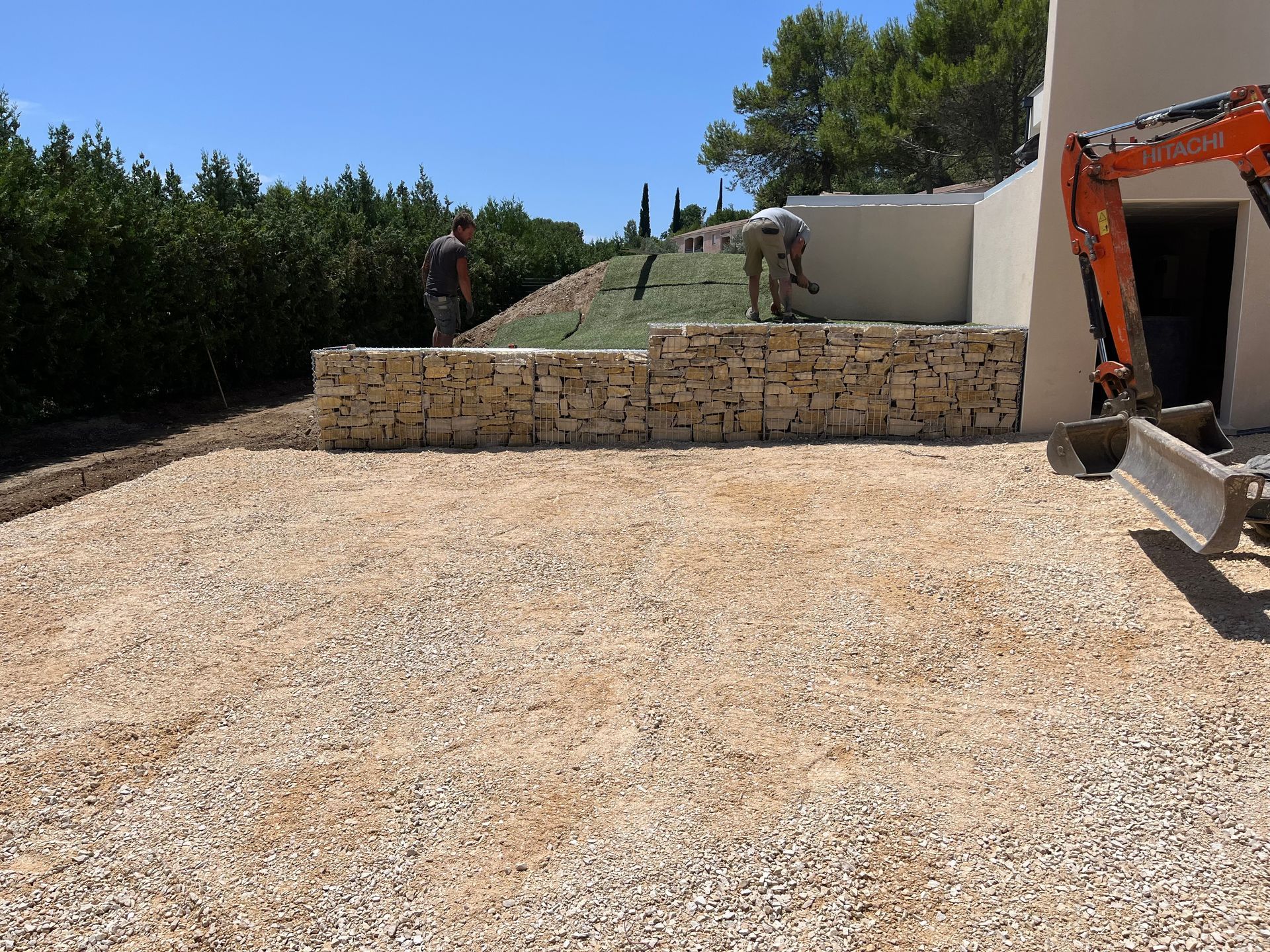 Pose d'un muret en pierre devant une maison