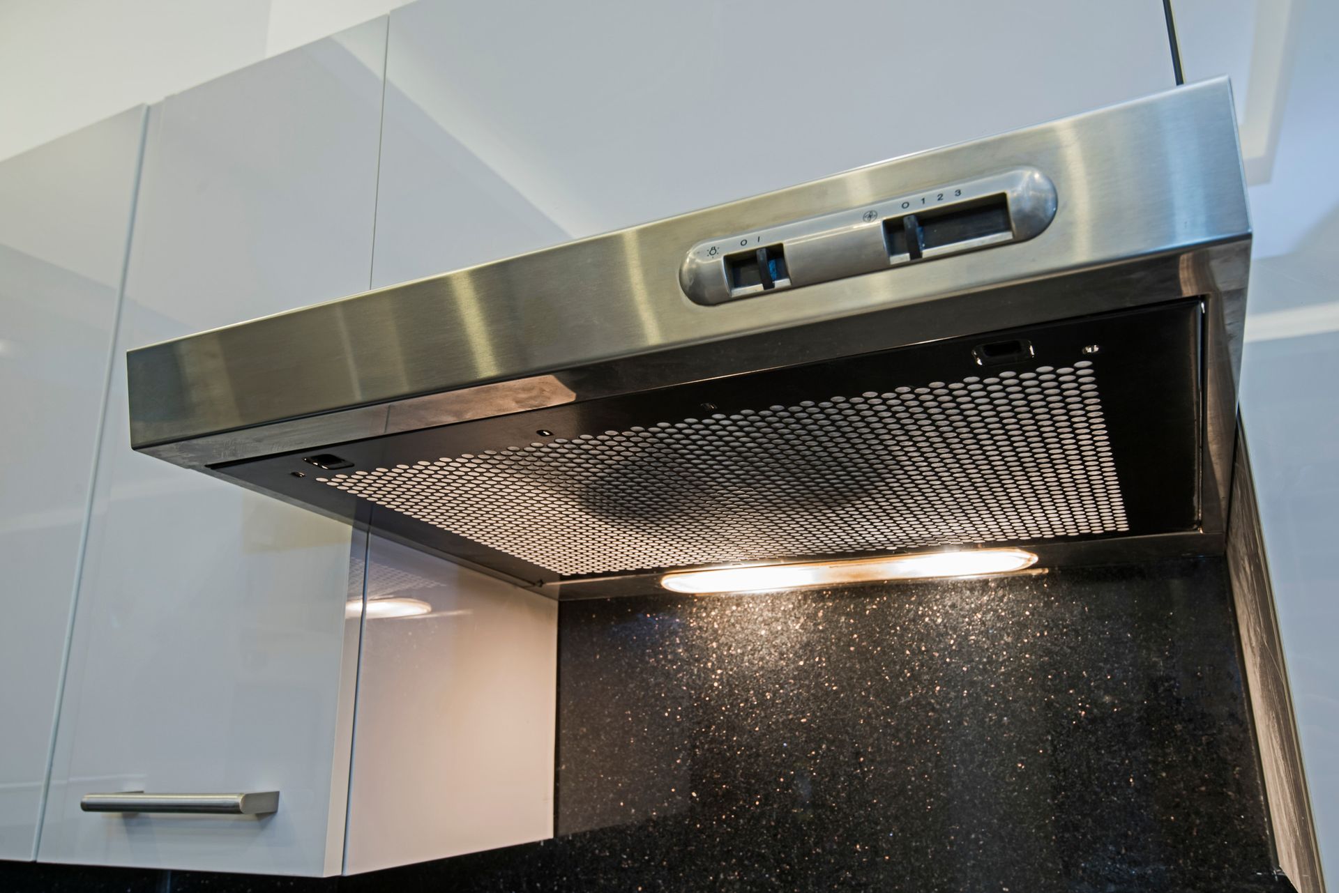 Una campana de acero inoxidable cuelga del techo de una cocina.