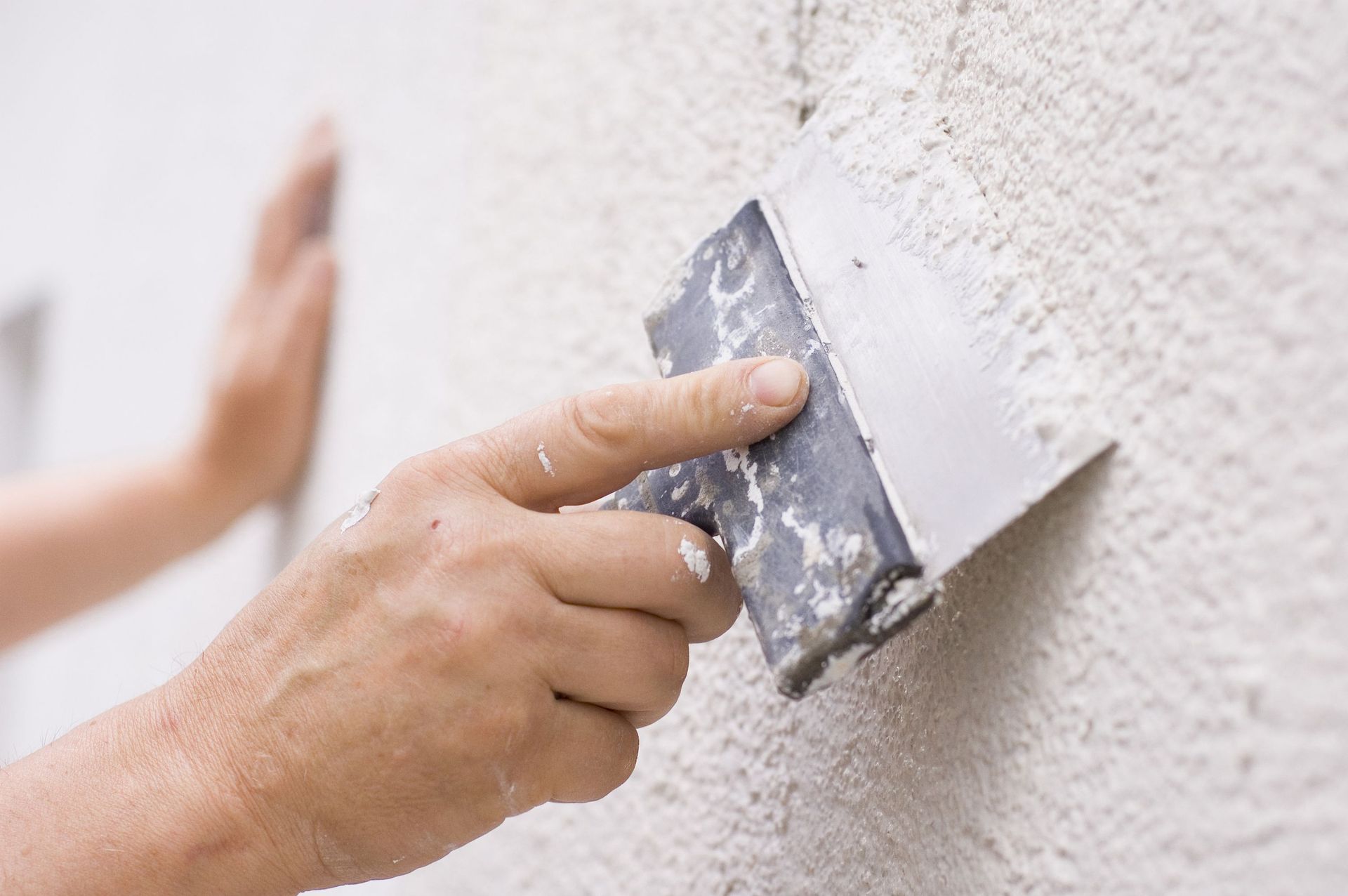 Una persona está enyesando una pared con una espátula.