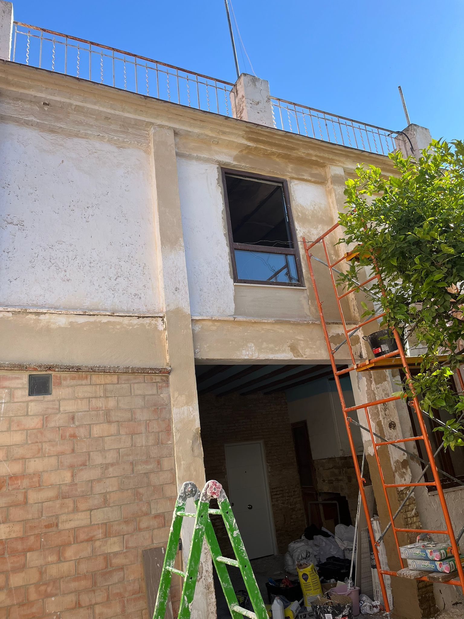 Una escalera verde está delante de un edificio de ladrillos.