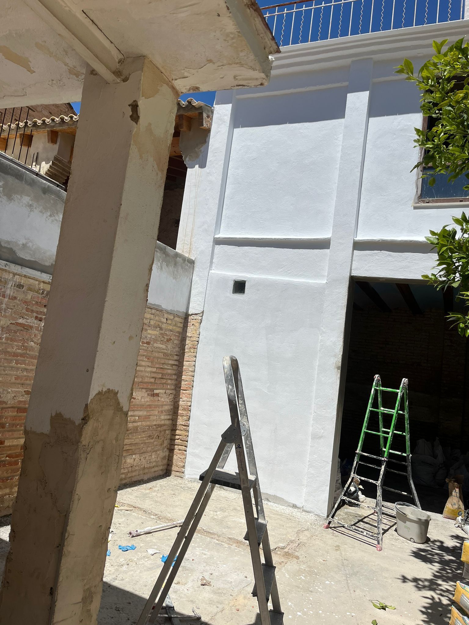 Una escalera está situada delante de un edificio blanco.