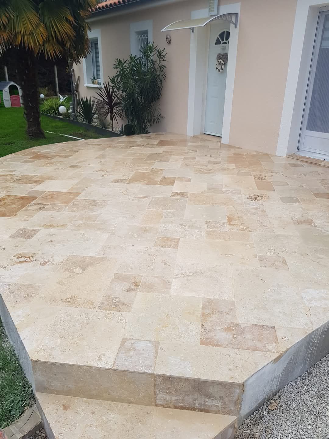 Un patio avec des escaliers qui y mènent devant une maison.