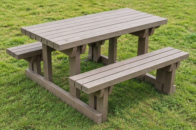 Mesa de pícnic de madera desgastada con bancos incorporados sobre el césped
