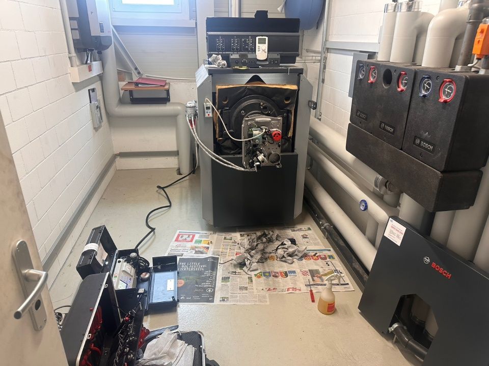 Ein Raum mit einem Boiler und einem Koffer auf dem Boden. Foto von der Schrepfer Heizungstechnik GmbH