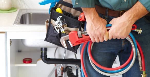 Plombier tenant une clé entre ses mains