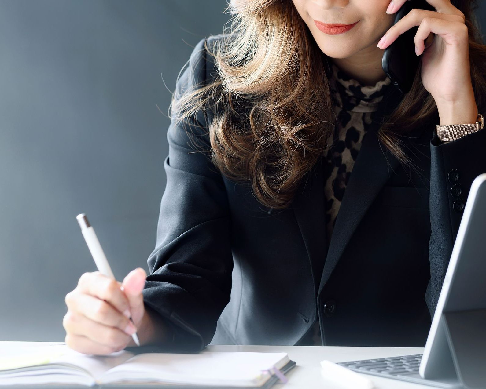 Avocate au téléphone qui écrit sur un calepin