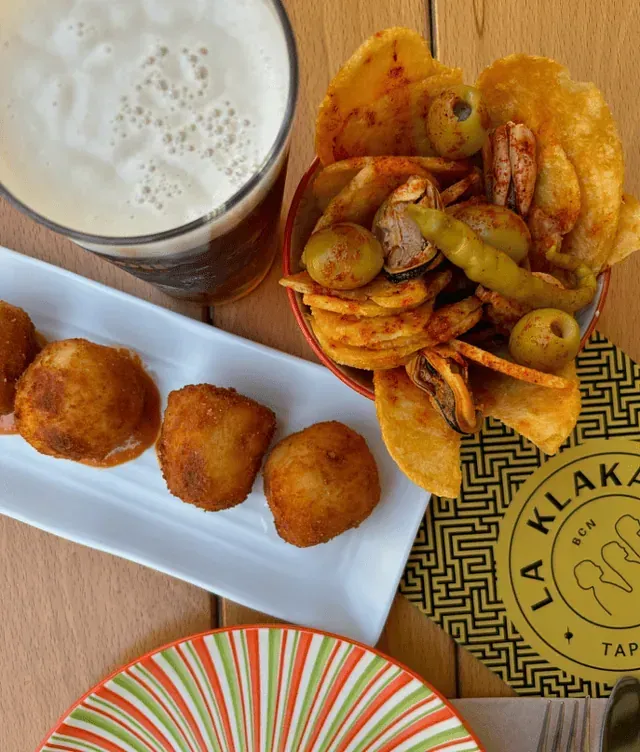 Un plato de comida está en una mesa junto a un vaso de cerveza.