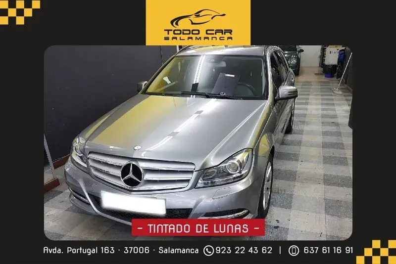 Silver Mercedes-Benz sedan in a shop with "TINTADO DE LUNAS" text.  "TODO CAR SALAMANCA" logo.