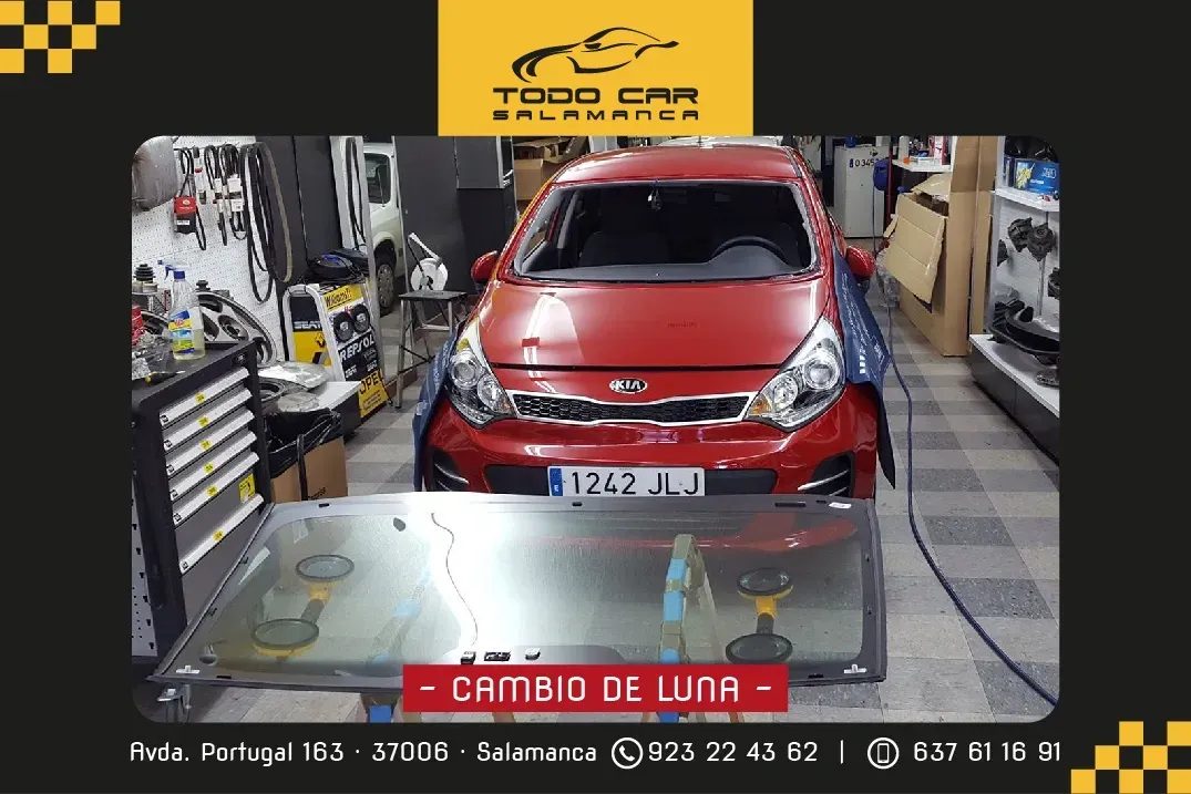 Coche rojo en un garaje con parabrisas nuevo. El texto dice "Cambio de luna". Se ve el logo de la tienda.