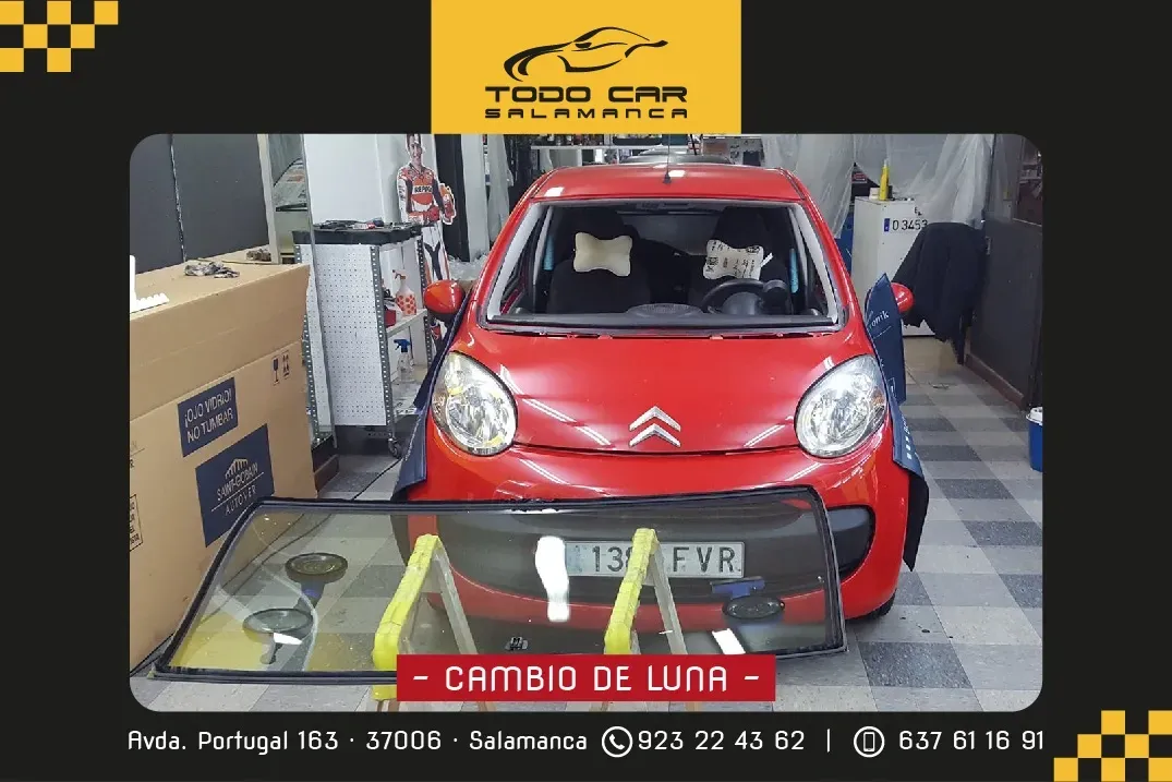 Automóvil rojo con parabrisas en proceso de reemplazo en taller Todo Car Salmantina.