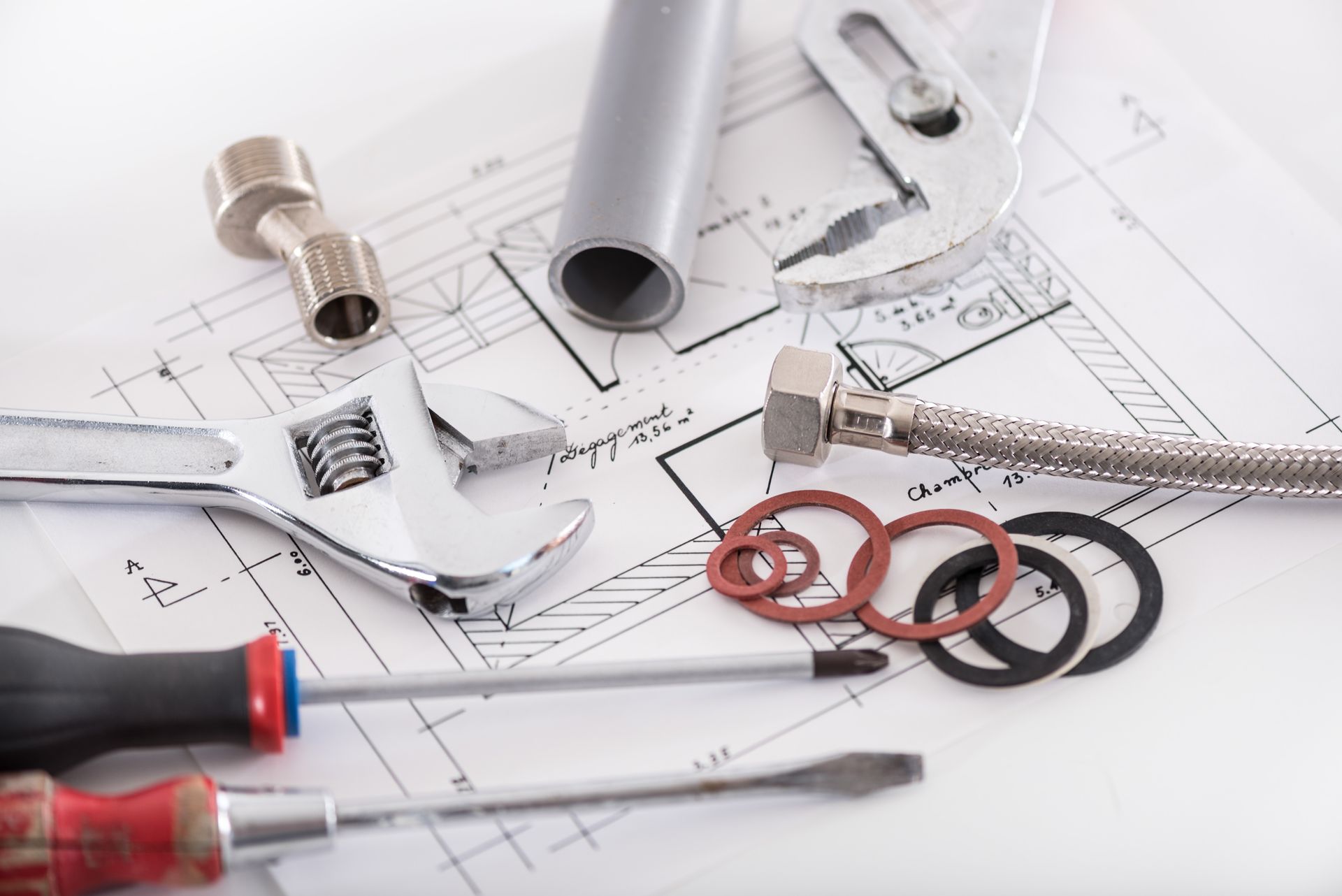 Outils et accessoires de plomberie figurant sur les plans architecturaux, notamment clés, vis et tuyaux.