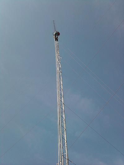 Un hombre está parado en lo alto de una torre muy alta.