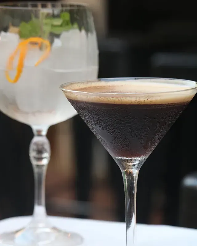 Un martini y un gin tonic están sobre una mesa
