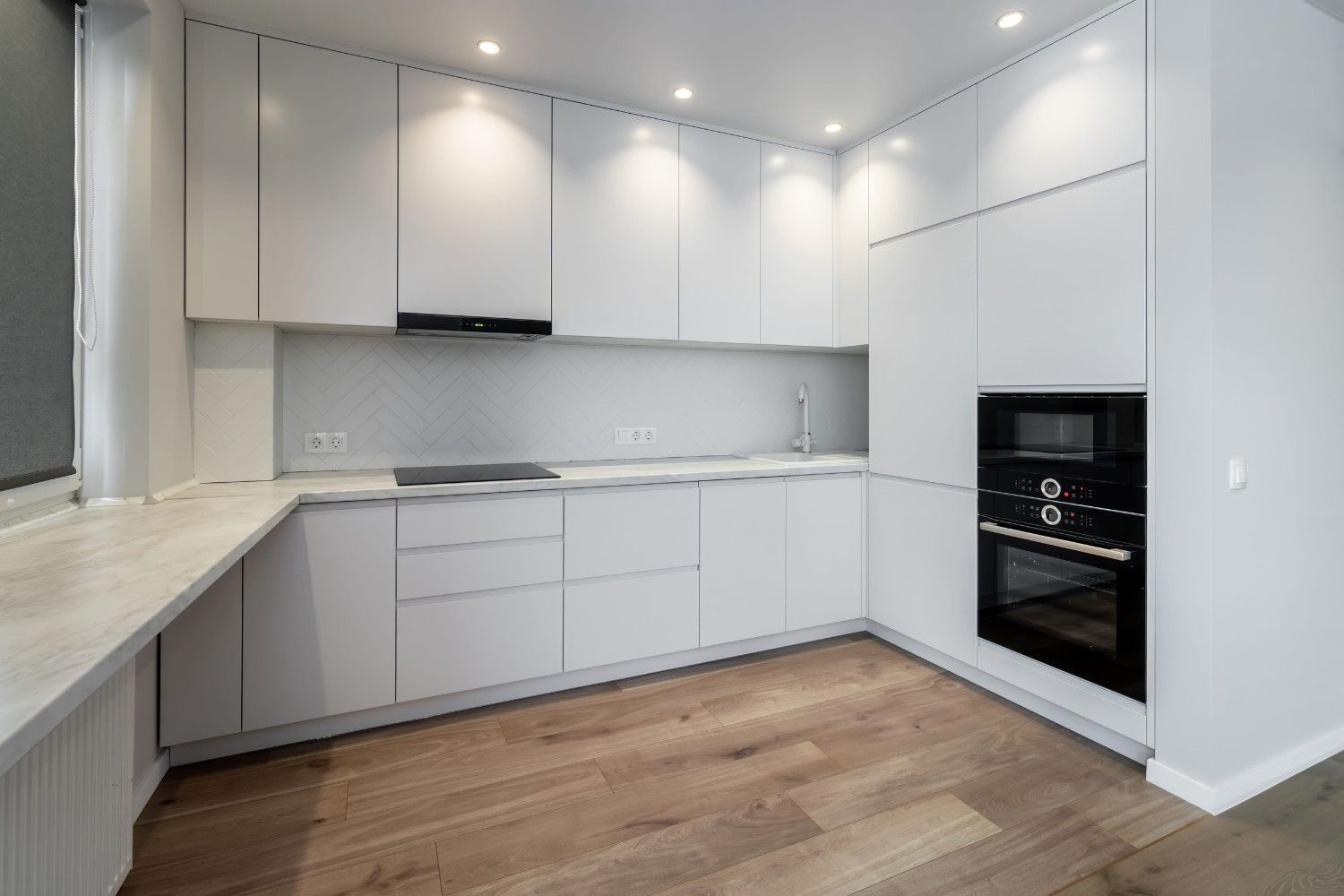 Cocina blanca luminosa con estanterías abiertas, estufa, armarios y una mesa puesta en primer plano.