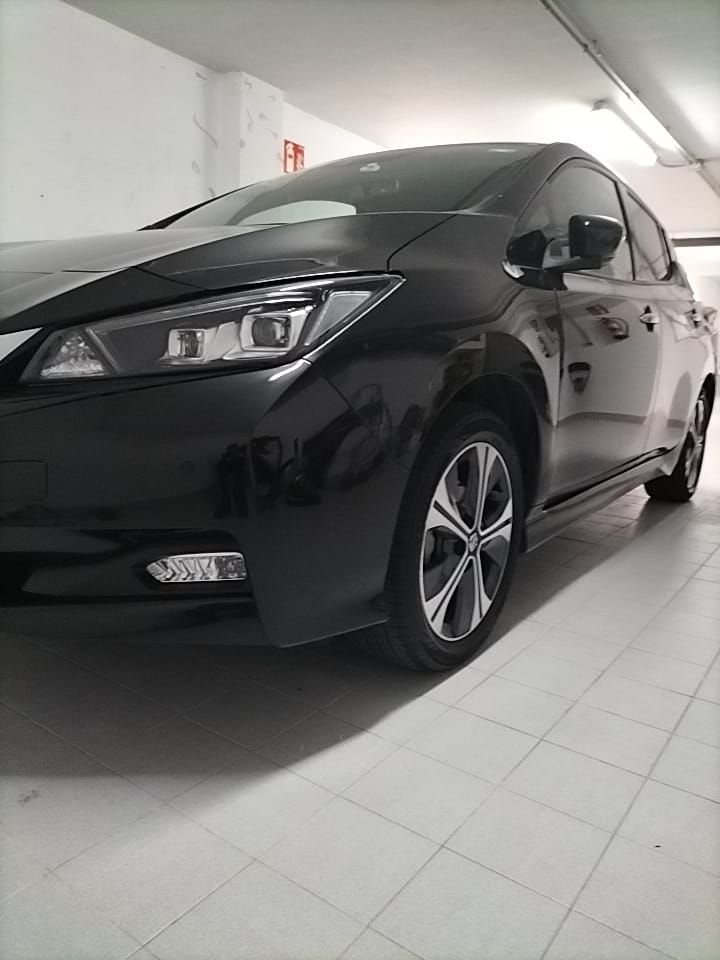 Un coche negro está aparcado en un garaje.