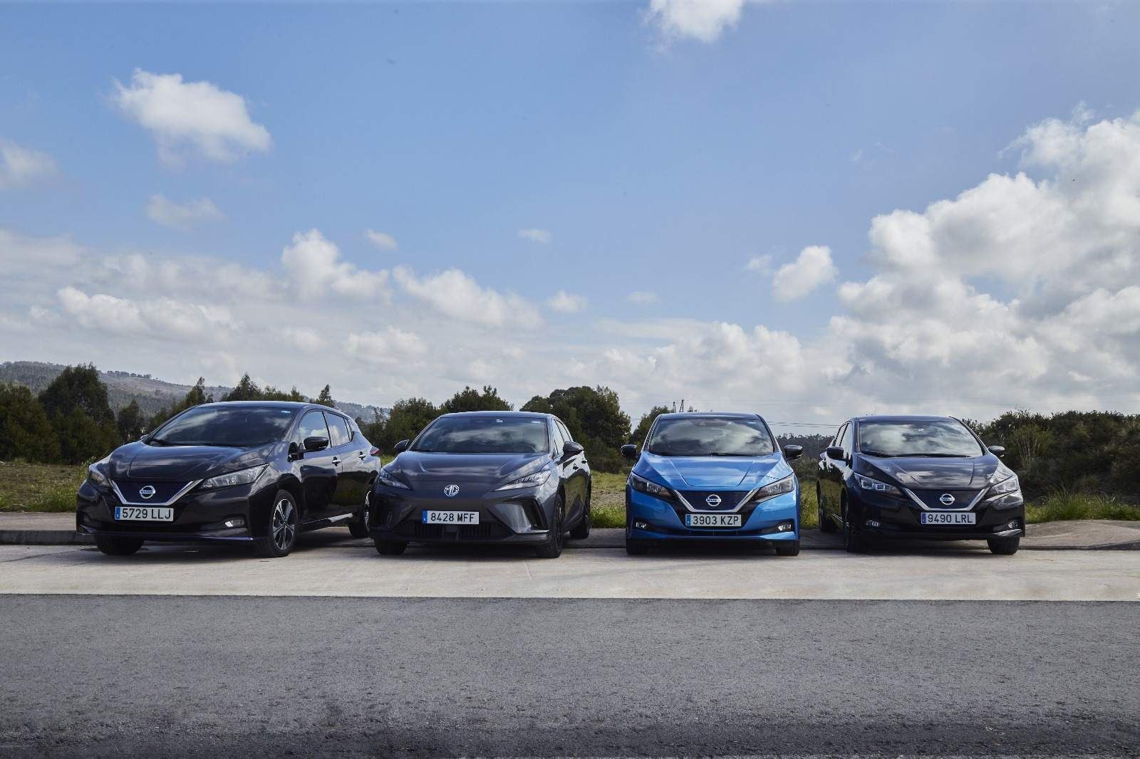 Una fila de coches están aparcados uno al lado del otro al costado de la carretera.