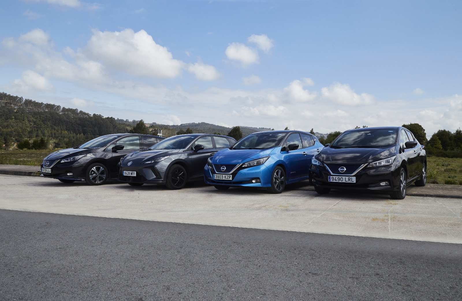 Cinco coches eléctricos Nissan Leaf aparcados al aire libre en un día soleado.