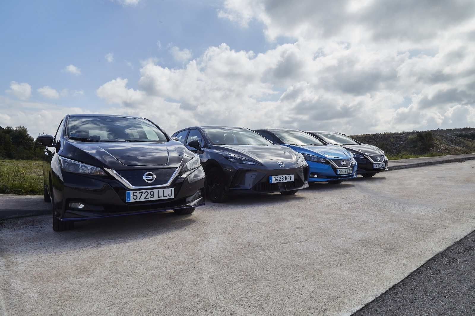 Una fila de coches eléctricos están estacionados en un estacionamiento.