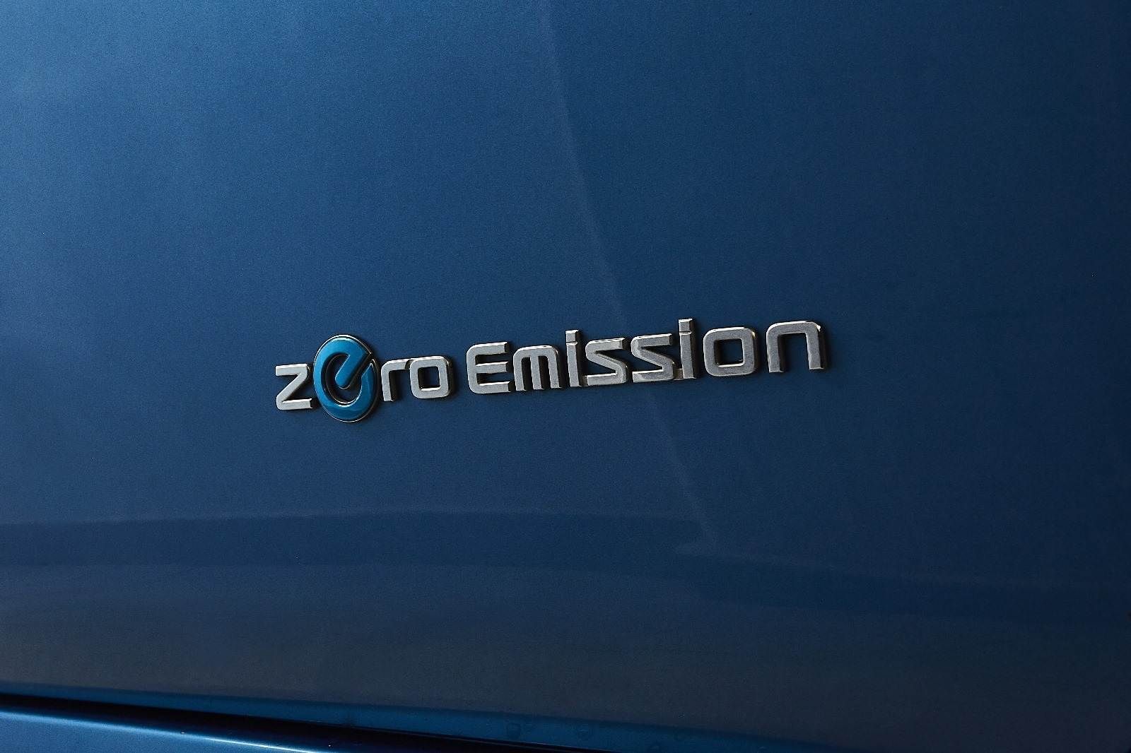 Un primer plano de un automóvil azul con la palabra cero emisiones.