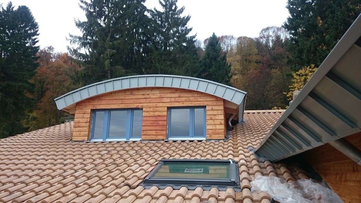 Ein Haus mit einem Dach, auf dem sich ein Oberlicht befindet