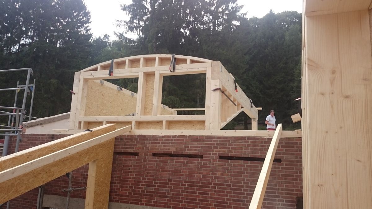 Auf einem Backsteingebäude wird eine Holzkonstruktion errichtet