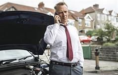 Mann neben Auto telefoniert Mann neben Auto telefoniert