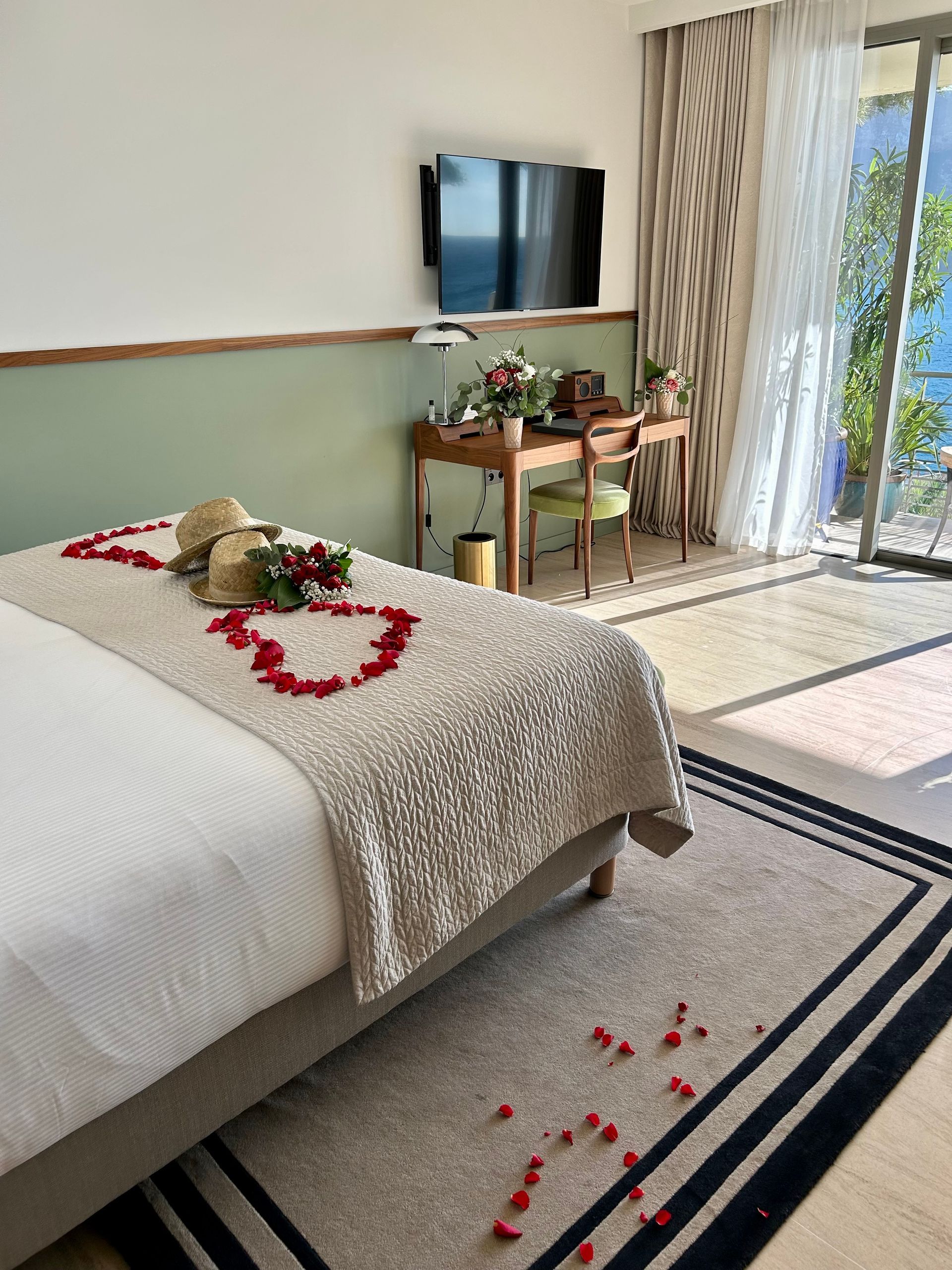 Chambre d'hôtel personnalisée avec des pétales de roses rouges sur le lit