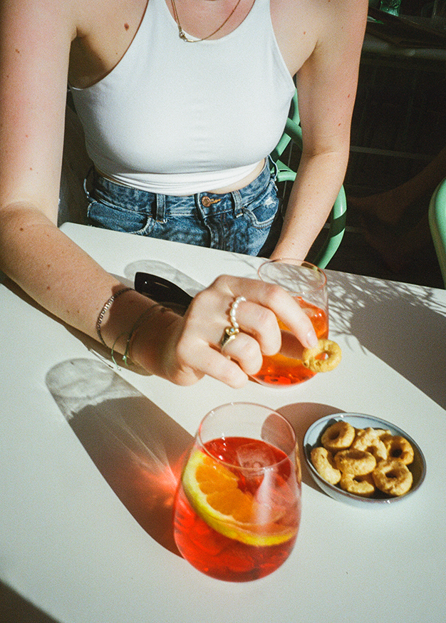 Zwei Gläser Wein vor der beleuchteten Aperitivo-Bar im Prater