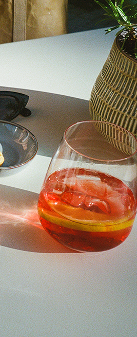 Auf einem Tisch steht ein Glas mit roter Flüssigkeit und Eis.