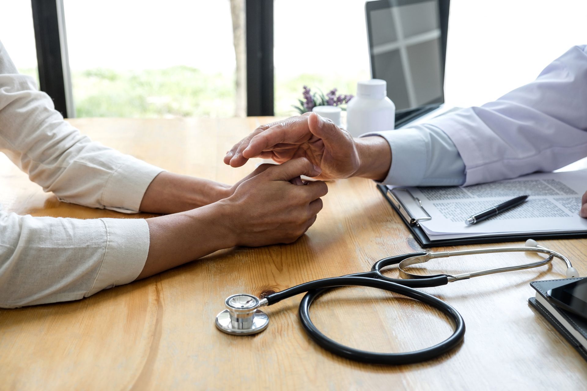 Deux personnes discutant et un stéthoscope sur la table