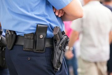 Un hombre policía portando su arma.