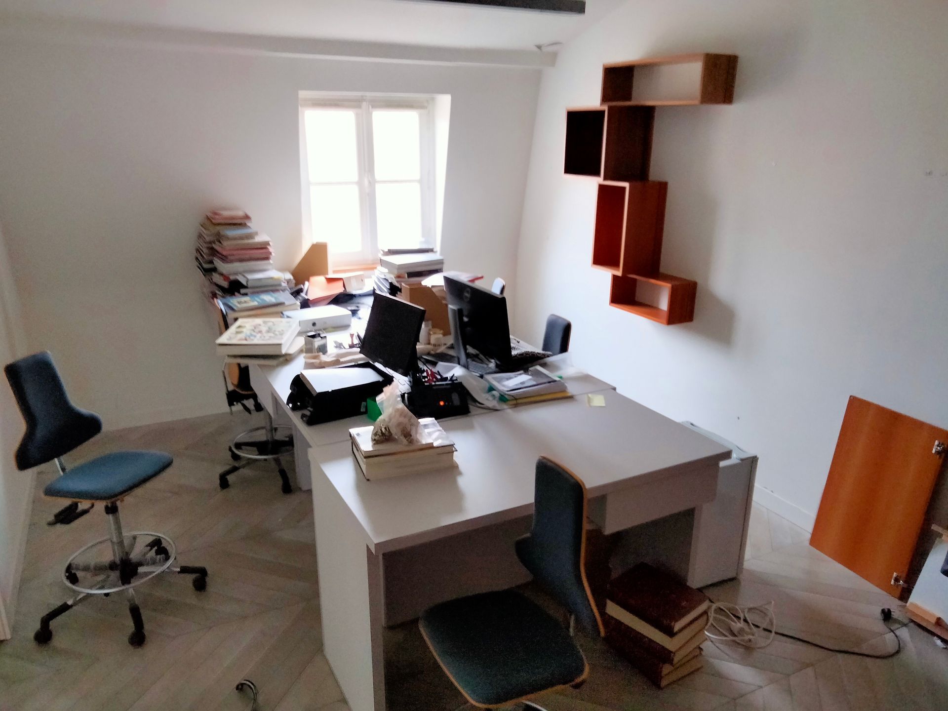 Bureau avec chaises, fenêtre et étagères.