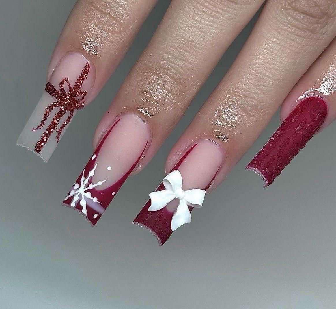 Un primer plano de las uñas de una mujer con un diseño de lazo y copo de nieve.