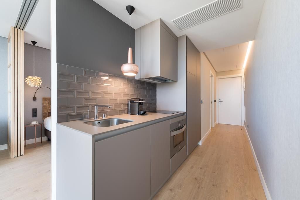 Una cocina con fregadero y estufa en una habitación de hotel.