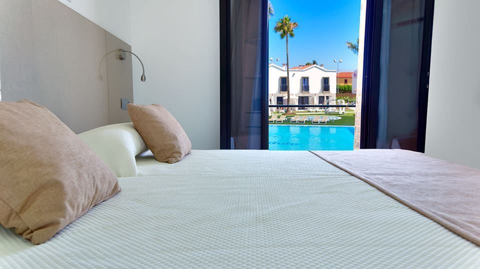 Un dormitorio con una cama y vista a una piscina.