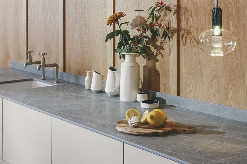 Una encimera de cocina con una tabla de cortar y limones encima.