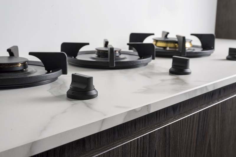 Un horno de leña está colocado encima de una encimera de mármol.